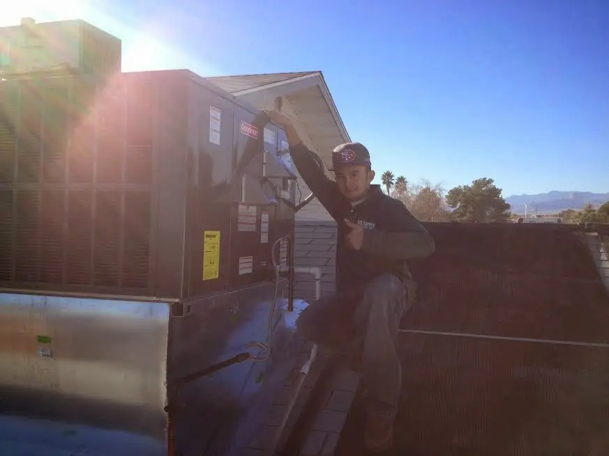 HVAC technician performing Heat Pump Repair on a rooftop unit in Pierre